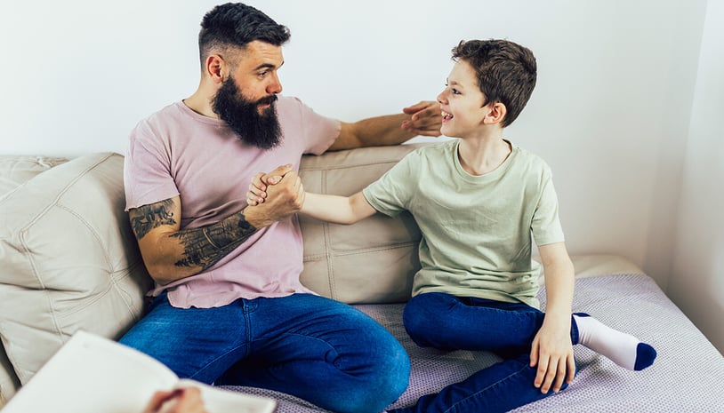 A father and son giving each other a celebratory handshake
